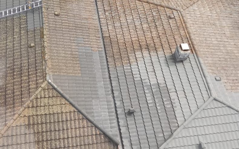 Dak waarvan een deel gereinigd is